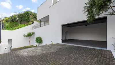 an open garage in a white house at Villa Jamboeiro by LovelyStay in Funchal