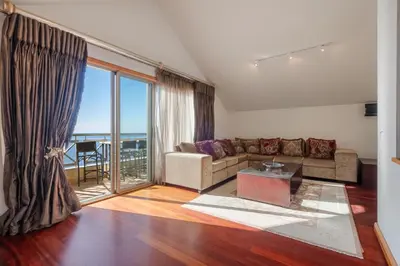 a living room with a couch and a large window at Cliff View Apartment - By Wehost in Funchal