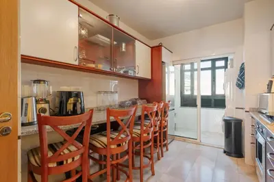 a kitchen with a bar with a row of chairs at Cliff View Apartment - By Wehost in Funchal