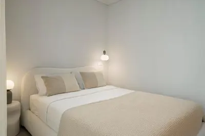 a white bedroom with a bed and a couch at With patio in Funchal city centre - AL'gria I in Funchal