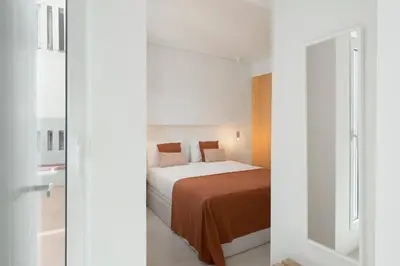 a small bedroom with a bed and a mirror at With patio in Funchal city centre - AL'gria I in Funchal