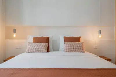 a large white bed with two pillows on it at With patio in Funchal city centre - AL'gria I in Funchal