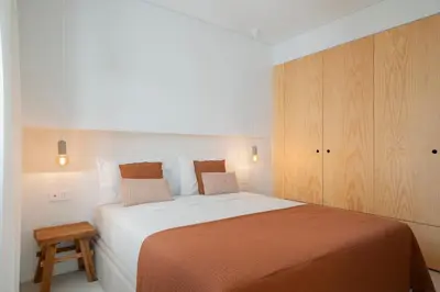 a bedroom with a large bed and a wooden cabinet at With patio in Funchal city centre - AL'gria I in Funchal
