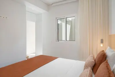 a white bedroom with a bed and a window at With patio in Funchal city centre - AL'gria I in Funchal