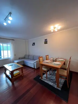 a living room with a table and a couch at Casa Do Arco - Machico Centre with Private Balconies and Parking in Machico