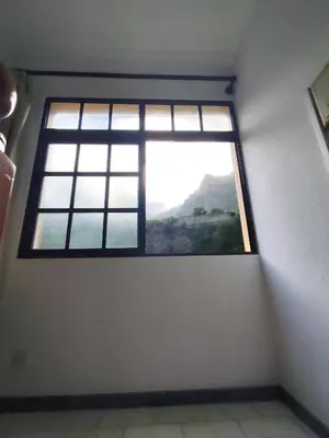 a window in a white room with a view at Narciso's House in São Vicente