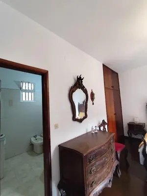 a bathroom with a dresser and a mirror on the wall at Narciso's House in São Vicente