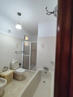 a bathroom with a tub and a toilet and a sink at Narciso's House in São Vicente