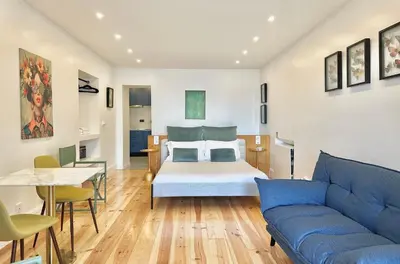 a bedroom with a bed and a table and a couch at Espada Preta Apartments in Câmara de Lobos