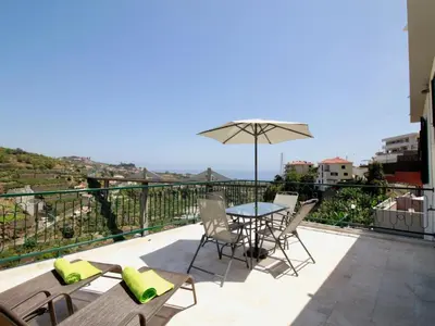 a patio with a table and chairs and an umbrella at Holiday Home Villa Lapa in Câmara de Lobos by Interhome in Câmara de Lobos