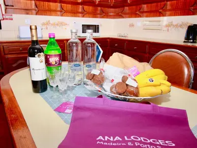 a table with a bowl of fruit and a bottle of wine at Holiday Home Villa Lapa in Câmara de Lobos by Interhome in Câmara de Lobos