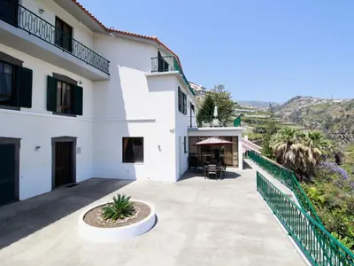 a white house with a balcony and a patio at Holiday Home Villa Lapa in Câmara de Lobos by Interhome in Câmara de Lobos