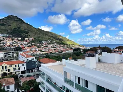 a view of a city with a hill in the background at Penthouse Montanha-Mar in Machico