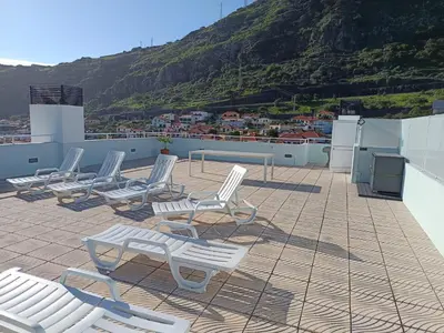 a group of chairs sitting on the roof of a building at Penthouse Montanha-Mar in Machico