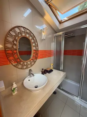 a bathroom with a sink and a mirror and a shower at Cozy Studio & Patio in Funchal in Funchal