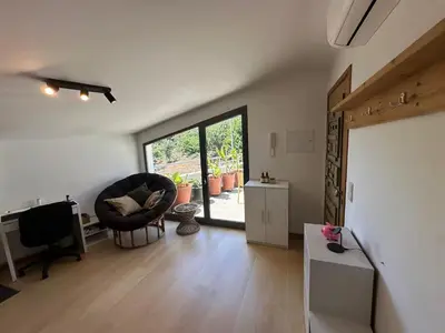 a living room with a chair and a television at Cozy Studio & Patio in Funchal in Funchal