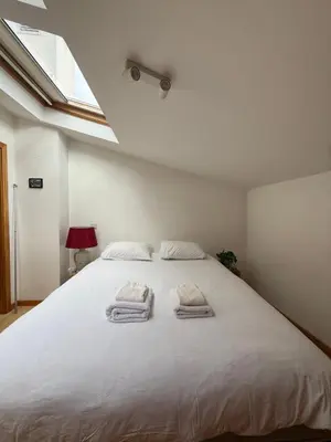 a bedroom with a large white bed with towels on it at Cozy Studio & Patio in Funchal in Funchal