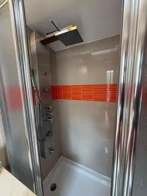 a bathroom with a shower with orange tiles at Cozy Studio & Patio in Funchal in Funchal