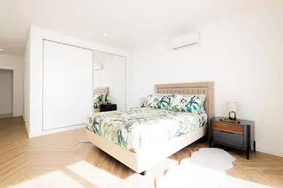 a bedroom with a bed and a mirror at Bela Vista - pool in Arco da Calheta