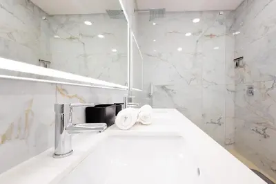 a white bathroom with a tub and a sink at Bela Vista - pool in Arco da Calheta