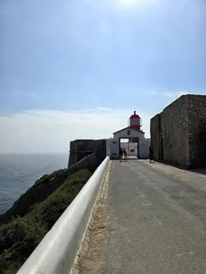 a lighthouse on a cliff next to the ocean at Sagres Escape Near Mareta Beach in Sagres