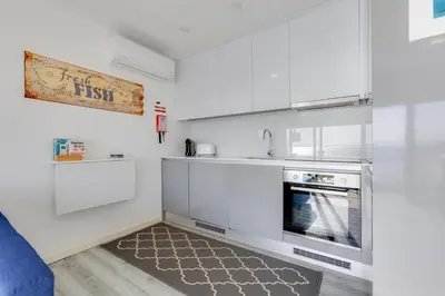 a kitchen with white cabinets and a stove at NEW Salema Seaview in Salema