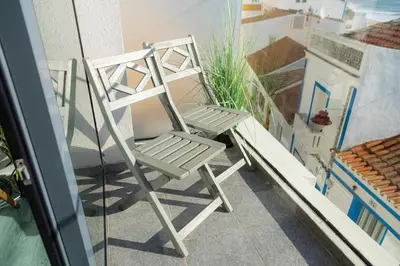 a white chair sitting on the side of a balcony at NEW Salema Seaview in Salema