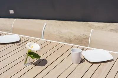 a wooden table with a flower in a vase on it at GuestReady - Escape with Ocean and Mountain Views in Calheta