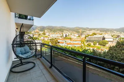 a balcony with a chair and a view of a city at Design Gardens Nº2 in Bicas