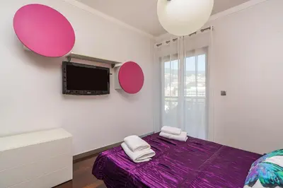 a bedroom with a purple bed and a tv at Design Gardens Nº2 in Bicas