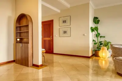 a living room with a book shelf and a table at Emma's Place, a Home in Madeira in Funchal