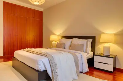 a bedroom with a large bed with white sheets and pillows at Emma's Place, a Home in Madeira in Funchal