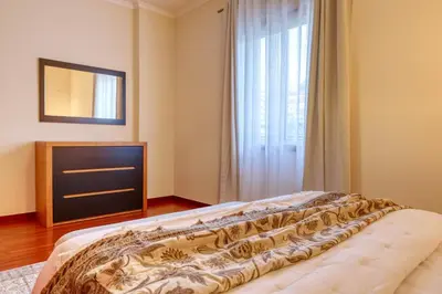 a bedroom with a bed with a dresser and a window at Emma's Place, a Home in Madeira in Funchal