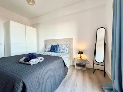 a bedroom with a bed with pink sheets and a dresser at Santa Luzia pokoje in Funchal