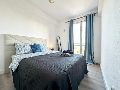 a bedroom with a bed with blue pillows and a window at Santa Luzia pokoje in Funchal