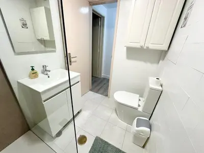 a white bathroom with a toilet and a sink at Santa Luzia pokoje in Funchal