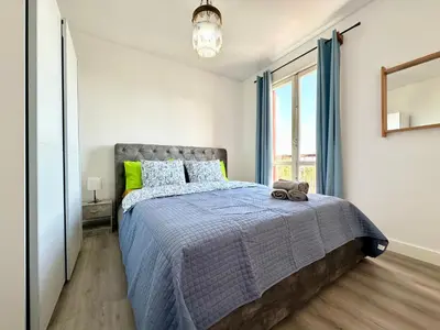 a bedroom with a bed with a blue comforter and a window at Santa Luzia pokoje in Funchal