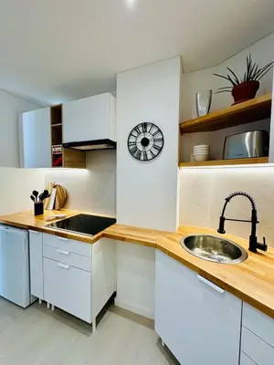 a kitchen with a sink and a clock on the wall at Dona Mécia in Funchal