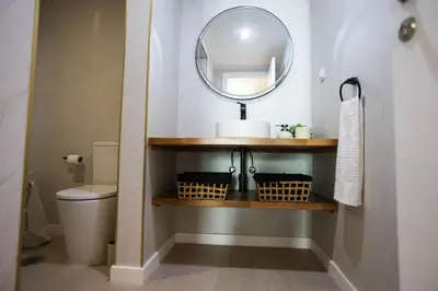 a bathroom with a mirror and a sink and a toilet at Dona Mécia in Funchal