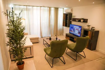 a living room with two chairs and a television at Dona Mécia in Funchal