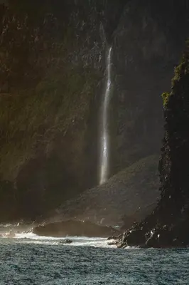 a waterfall on the side of a mountain next to the ocean at Casa Alba - Sunrise and Sea View Balcony - Apt 1 in Seixal