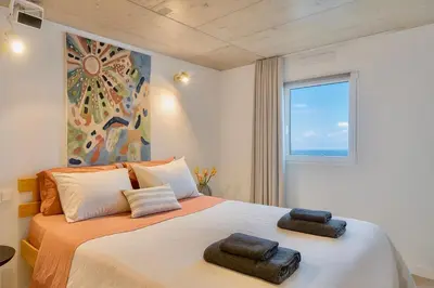 a bedroom with a large bed with two towels on it at Casa Alba - Sunrise and Sea View Balcony - Apt 1 in Seixal
