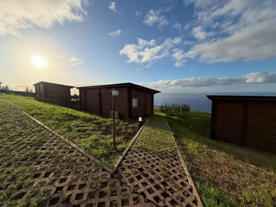 a couple of buildings on top of a grassy hill at Sunset Eco Shelter 2 in Ponta do Pargo