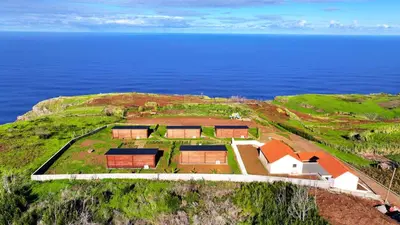 an aerial view of a house on a hill next to the ocean at Sunset Eco Shelter 2 in Ponta do Pargo