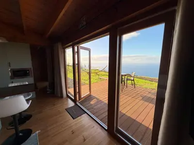 a room with a sliding glass door with a view of the ocean at Sunset Eco Shelter 2 in Ponta do Pargo