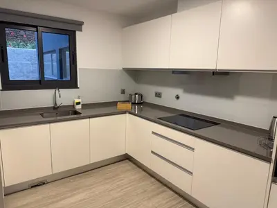 a kitchen with white cabinets and a window at Penteada Golden Residence in Funchal