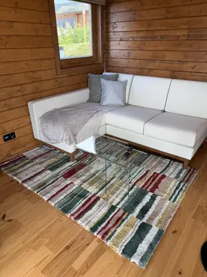 a white couch sitting on top of a rug at Sunset Eco Shelter 3 in Ponta do Pargo