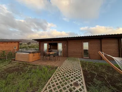 a house with a deck with a table and a grill at Sunset Eco Shelter 4 in Ponta do Pargo