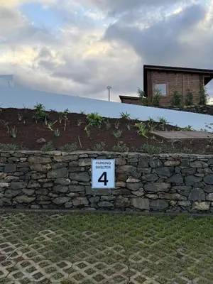 a stone retaining wall with a sign on it at Sunset Eco Shelter 4 in Ponta do Pargo