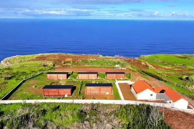 an aerial view of a house on a hill next to the ocean at Sunset Eco Shelter 4 in Ponta do Pargo